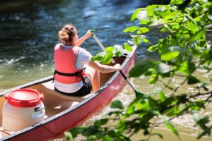Canoë naviguant sur l'Ill au cœur de la réserve naturelle de l'IllWald avec les Canoës du Ried à Sélestat.